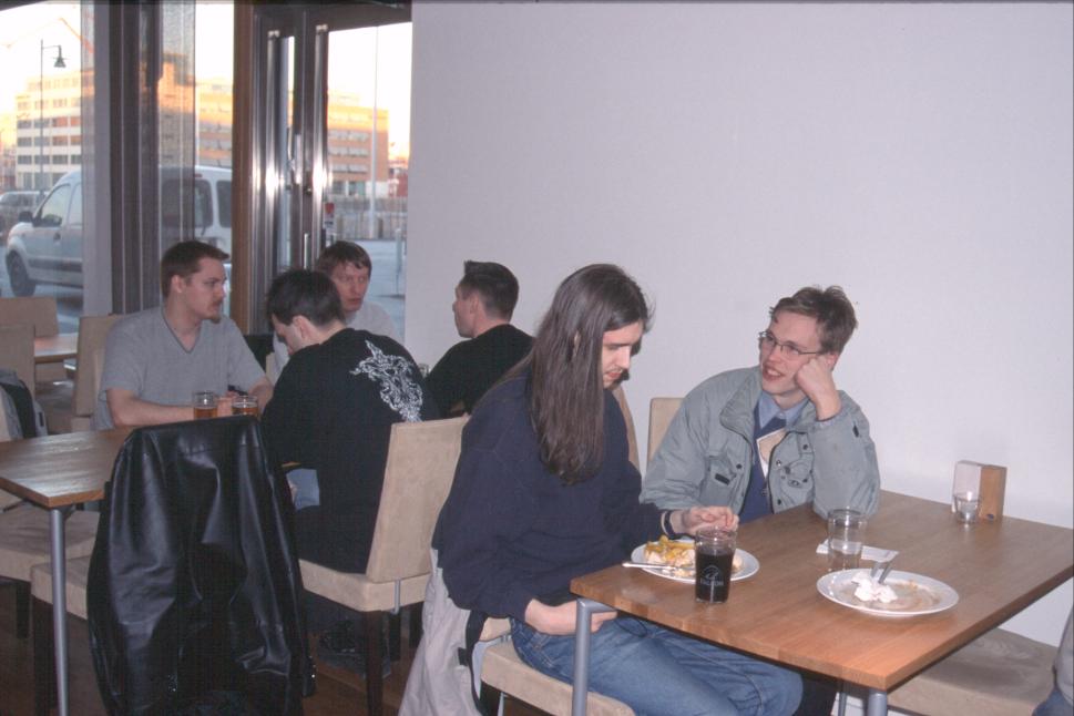 More Swedish Amigans, among them Brian from SyntaxSociety in the grey T-shirt at the farthest table, and coopdot (Peter Eriksson) studying his plate in the foreground, while Jonas looks at him in admiration. Coopdot brought his video gear as usual and made a video of the AROS presentation the next day, among other things.
