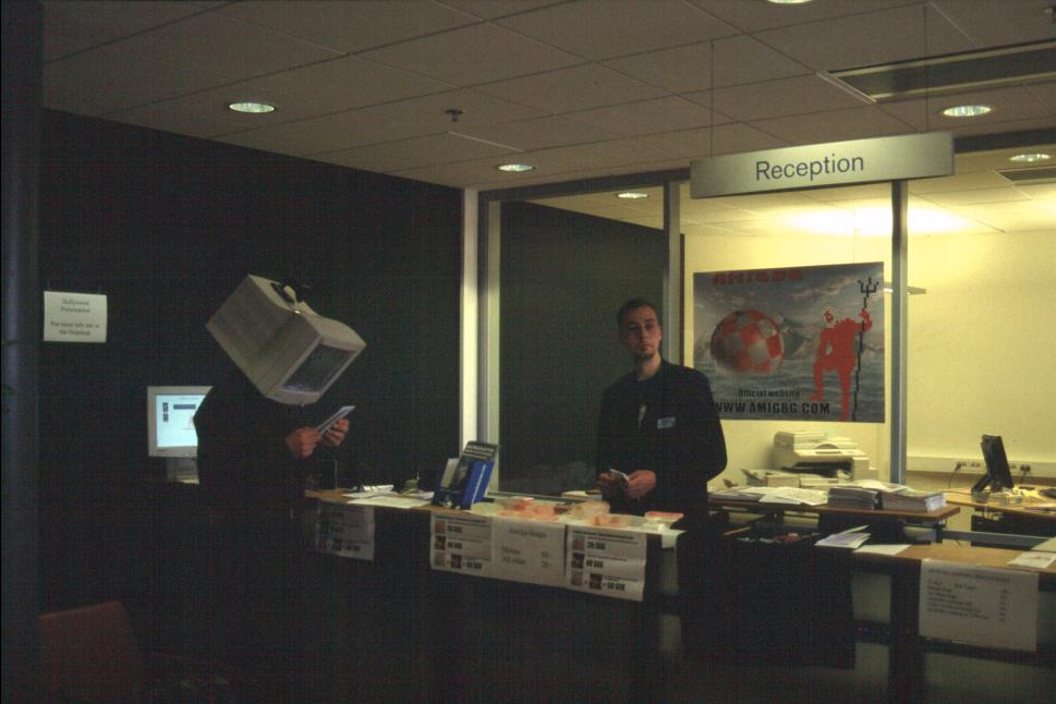 Sharakmir manning the reception desk while the monitor-head guy walks by. Rumour has it it was Walder of Syntax Society, BTW.