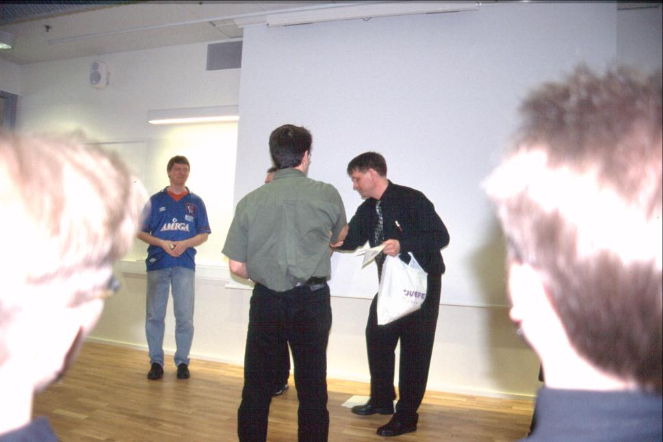 Tommy Strand from NAF handing out prizes for their own quiz, while Johan "Malm&ouml;killen" Wahlstr&ouml;m in the blue Amiga shirt is getting ready to get his.